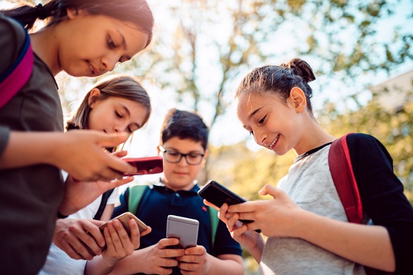 grup de copii care se uita pe telefoane