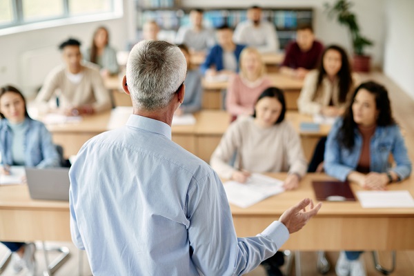 profesor matur stand in fata elevilor sau studentilor in clasa