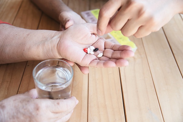 femeie in varsta care este indrumata cum sa-si ia medicamentele