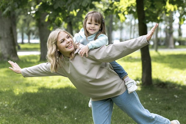 mama care se distreaza cu fetita ei intr-un parc