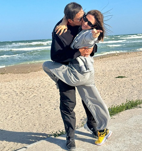Adela Popescu fericita, in timp ce sotul ei, Radu Vâlcan, o saruta pe obraz la malul mării