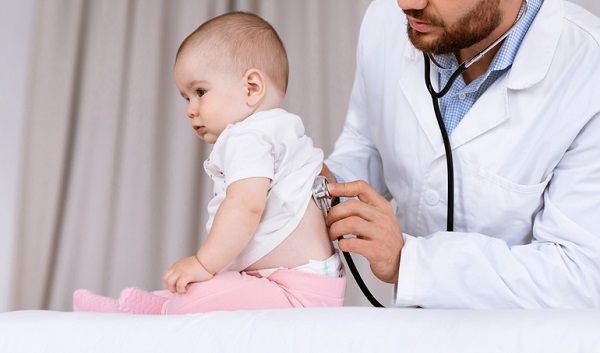 medic care asculta la plamani un bebelus ce sta in sezut
