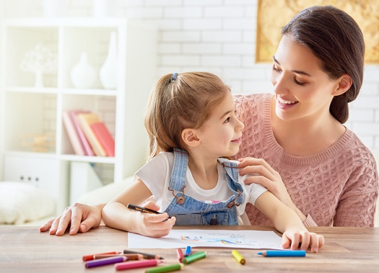 fetita care deseneaza in timp ce sta de vorba cu mama ei