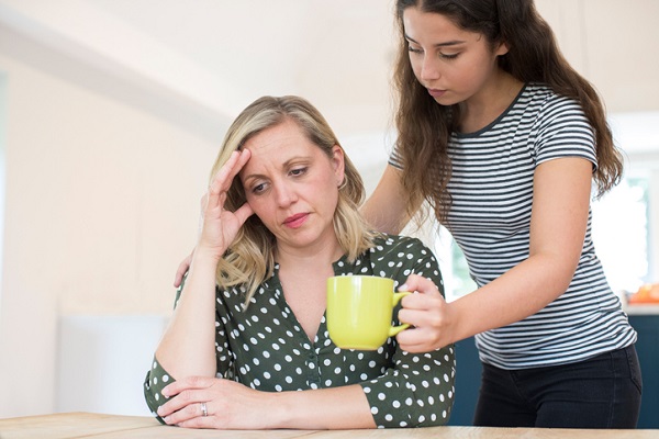 adolescenta care îi aduce o cana mamei sale deprimate