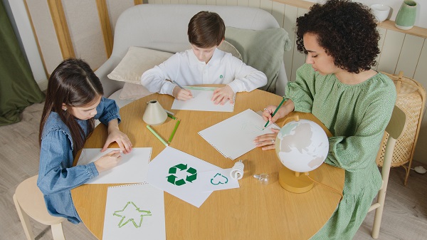 mama si copii confectionand impreuna semne distinctive pentru a recicla corect deseurile