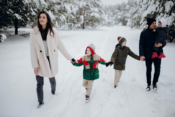 parinti cu trei copii plimbandu-se intr-o zi de iarna