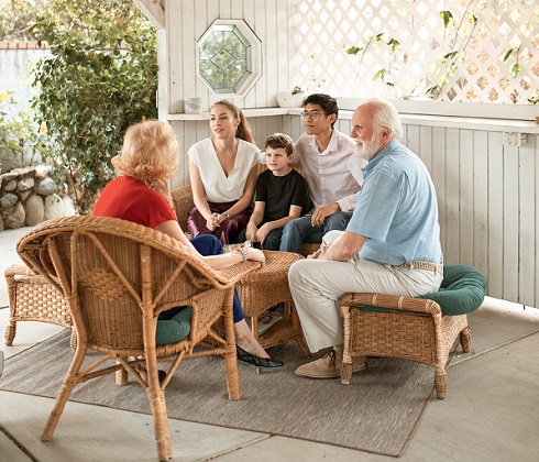familie tanara la o discutie cu bunicii pe terasa