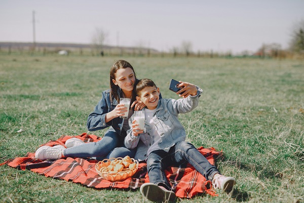 adolescenti care sunt la un picnic in natura si isi fac un selfie