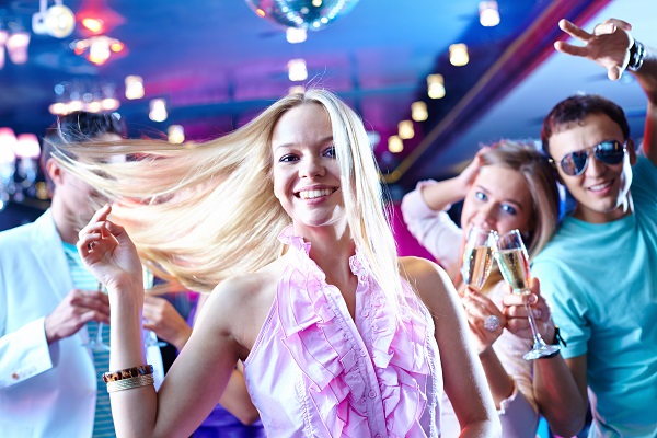 femeie tanara blonda dansand si distrandu-se cu prietenii in club