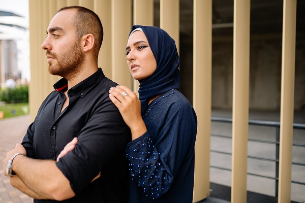 femeie care poarta val musulman si atinge spatele partenerului ei