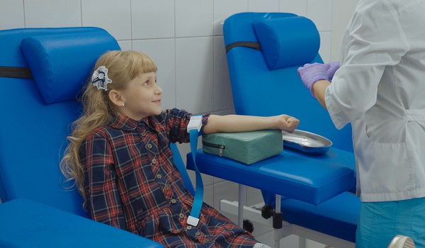 fetita care se pregateste sa i se recolteze sange pentru analize