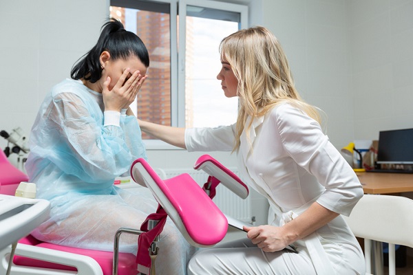 femeie ginecolog care isi incurajeaza pacienta speriata