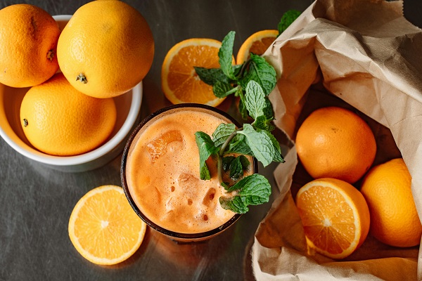 portocale intregi si suc de portocale cu gheata si frunze de menta