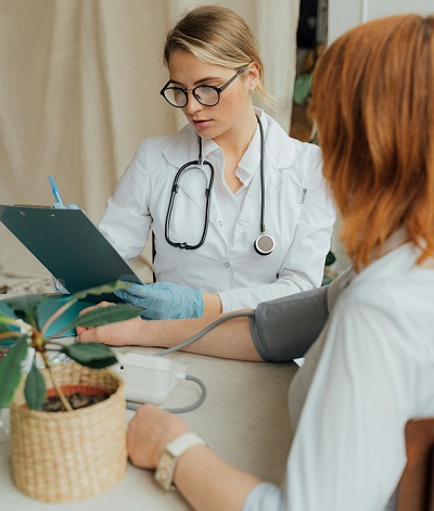 doctorita monitorizand tensiunea arteriala unei paciente