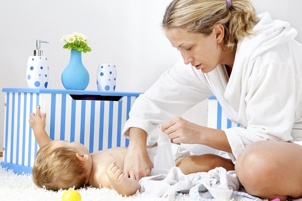 mama care schimba scutecul bebelusului ei dupa baie