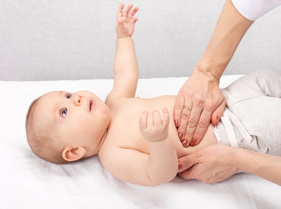 cadru medical care palpeaza burtica unui bebelus