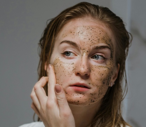 femeie tanara care isi exfoliaza fața