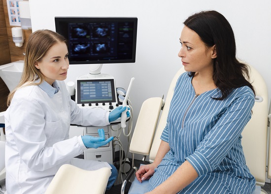 pacientă la consult ginecologic pregătindu-se de o ecografie transvaginală