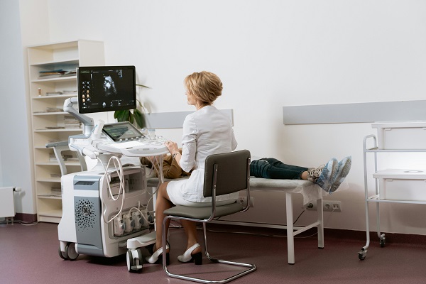 doctorita care efectueaza o ecografie prenatala pacientei sale