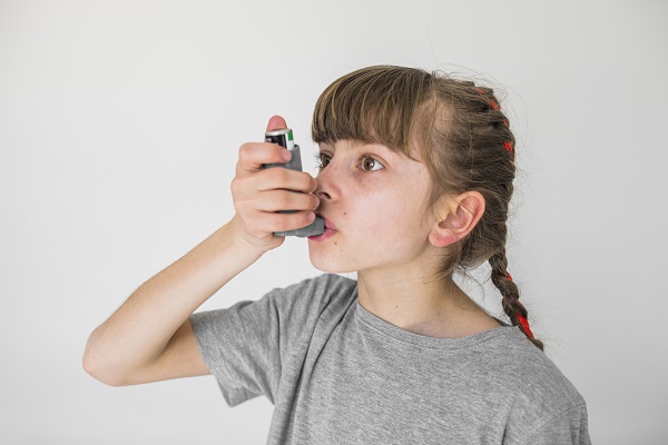 adolescentă care folosește un inhalator pentru astm
