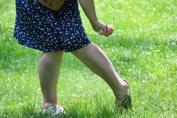 femeie care pulverizează pe picioare un spray repelent