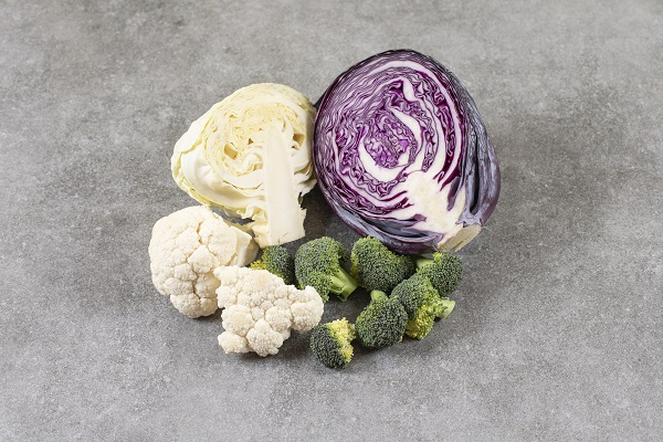 buchetele de conopida, buchetele de broccoli, bucata de varza alba si de varza rosie puse pe o suprafata gri