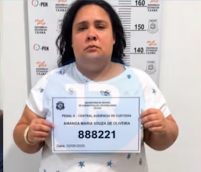 captură video YouTube,Amanda Maria Souza de Oliveira, femeia din Brazilia care s-a prefacut ca are 12 ani pentru a fi primita intr-o familie, imbracata cu tricou alb cu stelute bleumarin, in timp ce tinea in mana o foaie de hartie care ii atesta condamnarea, stand cu spatele la un perete pe care se masoara inaltimea