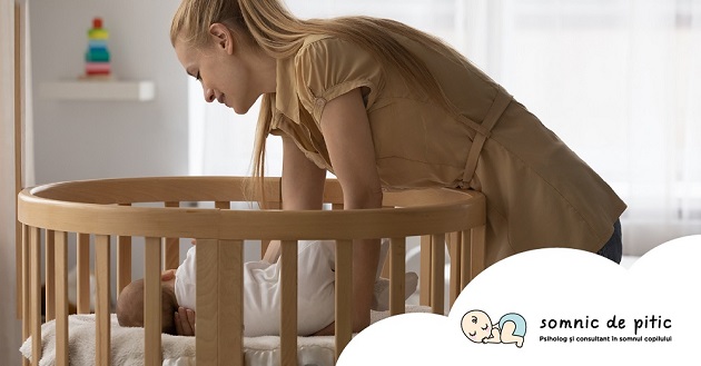femeie aplecata sa puna bebelusul la somn