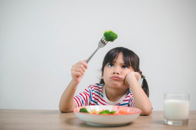 fetita care se uita la broccoli