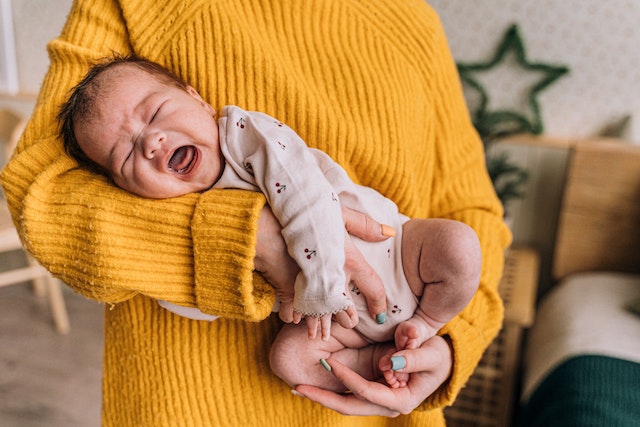 copil care plange la mama in brate