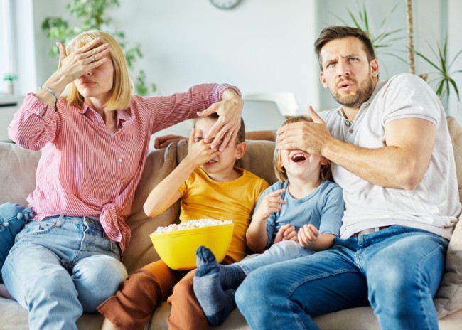 familia se uita la filme horror pe canapea