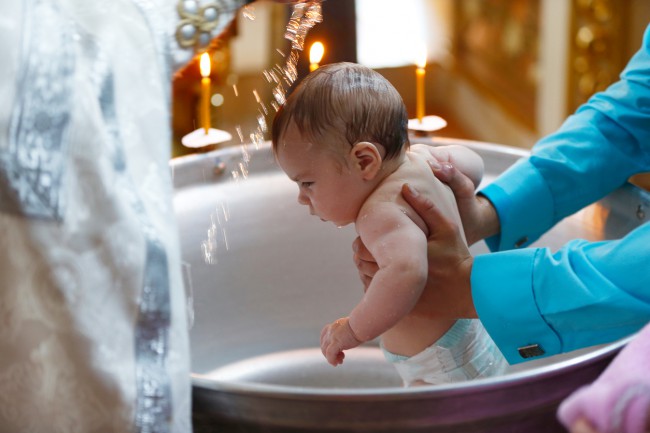 bebelusu scufundat in cristelnita in timpul botezului