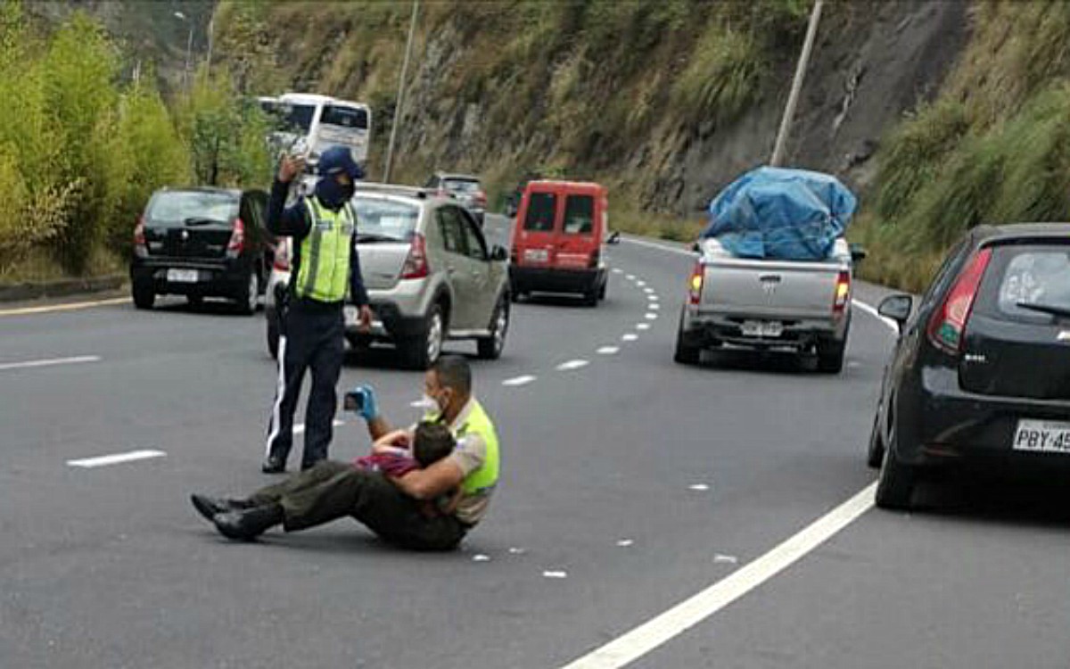 un politist consoleaza pe sosea un baietel dupa un accident de masina