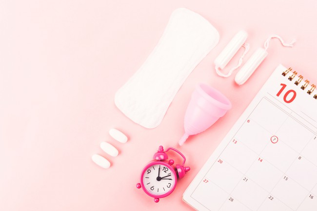imagine in care apar un calendar, un ceas desteptator, un absorbant zilnic, doua tampoane interne, o cupa menstruala si 3 pastile