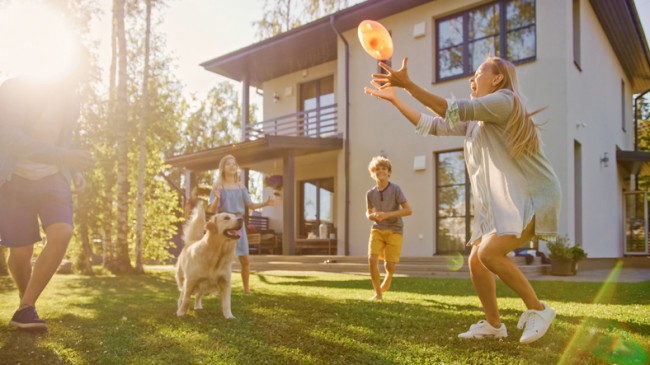 familie cu copii care se joaca in curtea casei