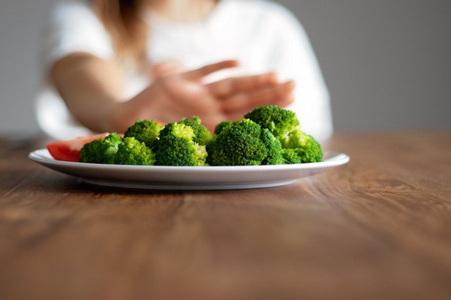 persoana care refuza o farfurie cu broccoli