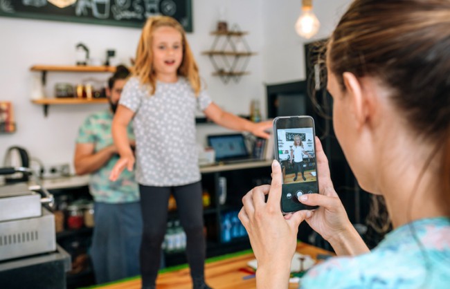 mama care isi filmeaza fiica cu telefonul