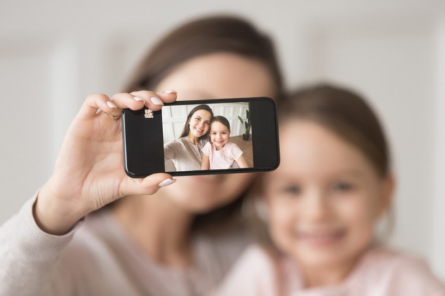mama si fiica care isi fac un selfie cu telefonul mobil