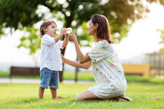 mama care ii da copilul sa bea apa dintr-o sticla