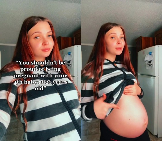 femeie roscata care isi arata burta de gravida