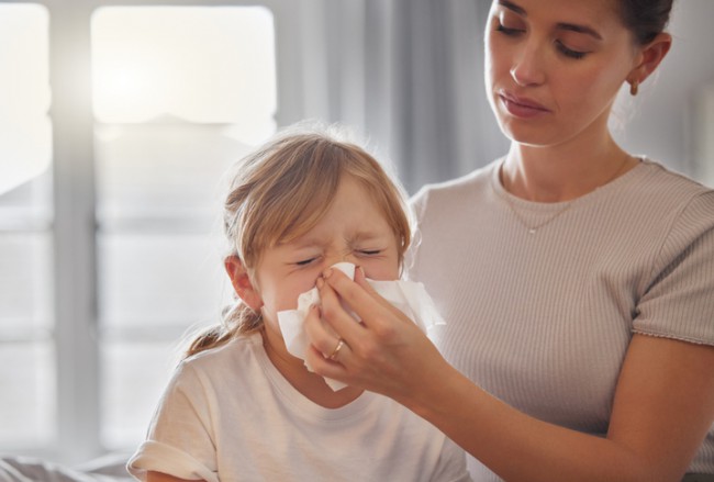 mama care isi ajuta fiica sa isi sufle nasul