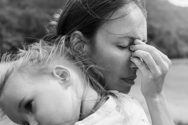 fotografie alb negru cu o mama trista care isi tine bebelusul in brate