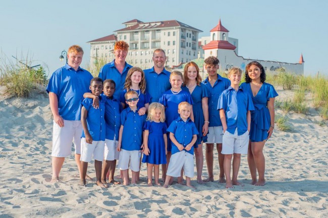 parinti cu 12 copii pe o plaja