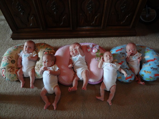 cinci bebelusi care stau pe podea