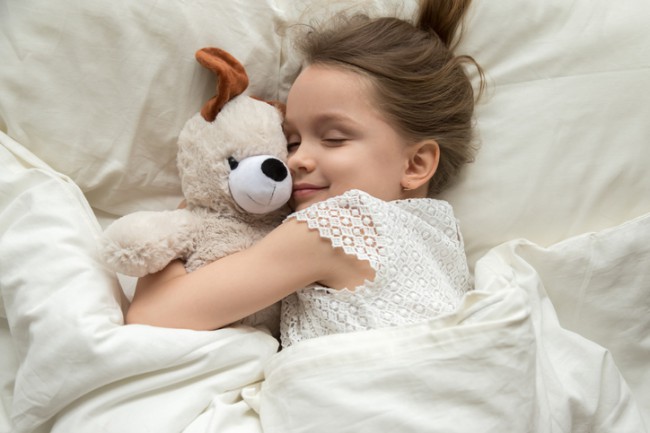 fetita care doarme cu un ursulet de plus