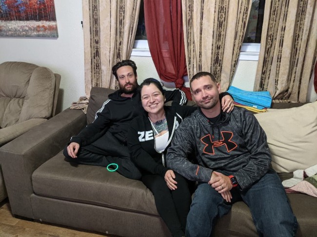 femeie care sta pe canapea cu doi barbati