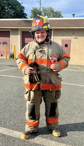 copil imbracat in costum de pompier