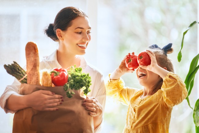 mama si fetita care tin in maini fructe si legume proaspete