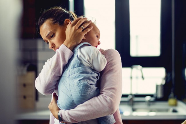 mama ingrijorata care isi tine bebelusul in brate