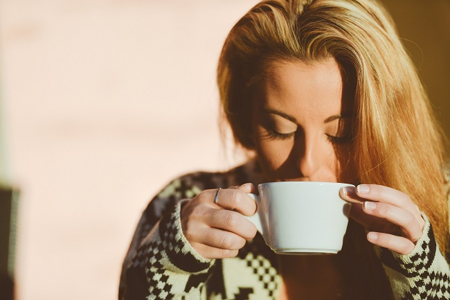 femeie blonda care bea ceai dintr-o ceasca alba